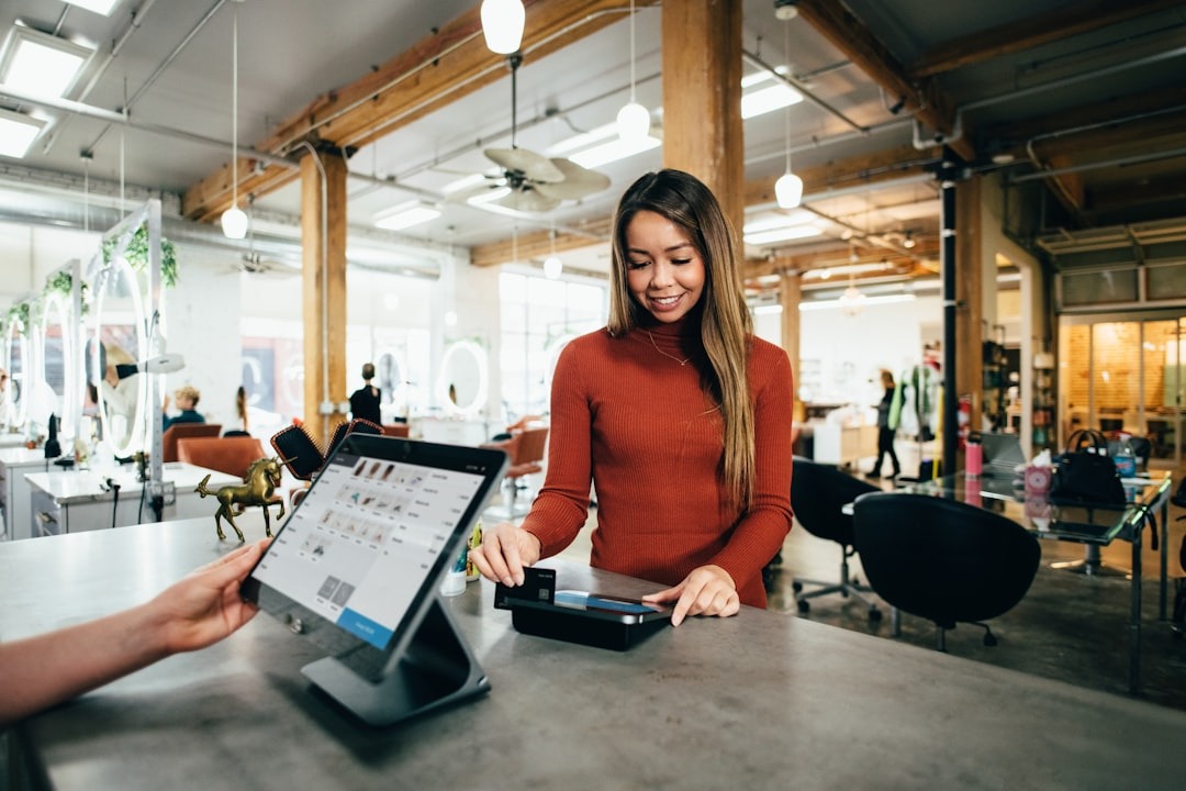 Woman pays with credit card at modern service counter.